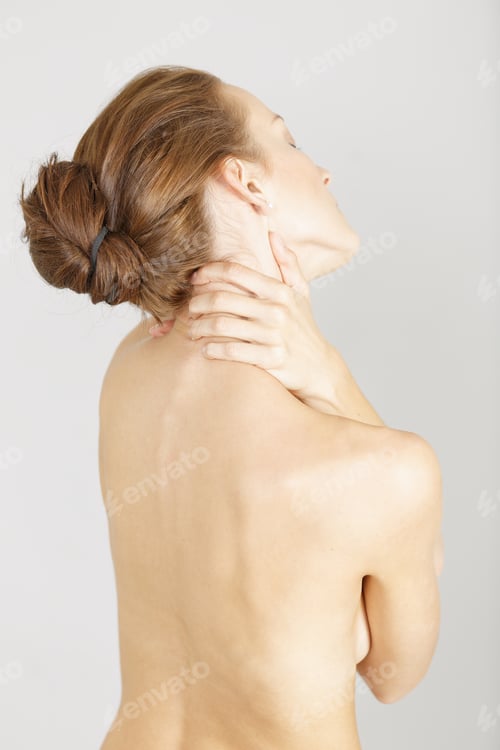 Preview: Young Woman Facing Away Massaging Her Neck From An Ache Or Pain