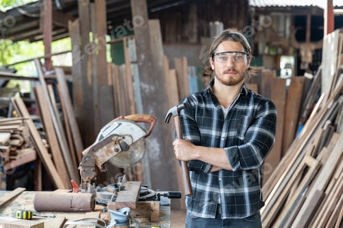 Preview: Portrait Of Confident Male Carpenter Holding Hammer At Carpentry Workshop. Male Woodworker At