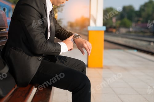 Preview: Businessman Sitting At Train Station Is Looking At Watch. He Looks On The Time And Hurrying In A