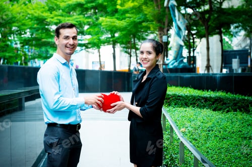 Preview: Young Business Leader Heart Concept. Young Business Man Giving A Heart To His Woman Co Worker In