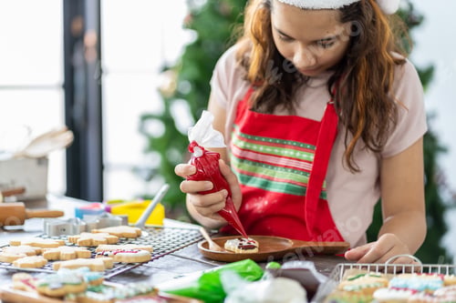Preview: Happy Child Girl In Kitchen Apron Decorating Xmas Cookies In The Kitchen With Christmas Tree At