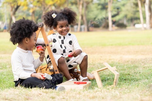 Preview: Two African American Little Boy And Girl Playing Toy Together In The Park. Children With Curly Hair