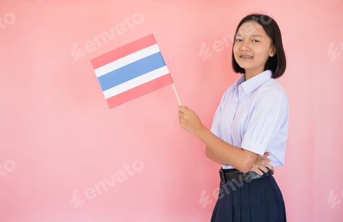 Preview: Portrait Asian Young Girl Hold Thai Flag With Pink Background In Student Uniform.