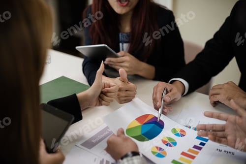 Preview: A Group Of Business Men And Women Are Meeting Together To See Graphs About Business Marketing Sales