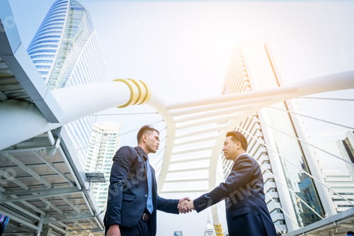 Preview: Two Asian Business Have Handshake With Building And City Background.
