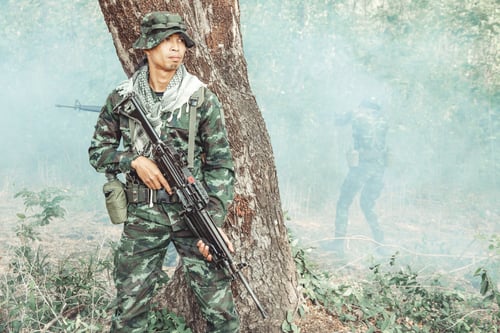 Preview: Soldier Standing Behind A Tree Ready To Attack. Chinese Male Soldier Standing Behind A Large Tree