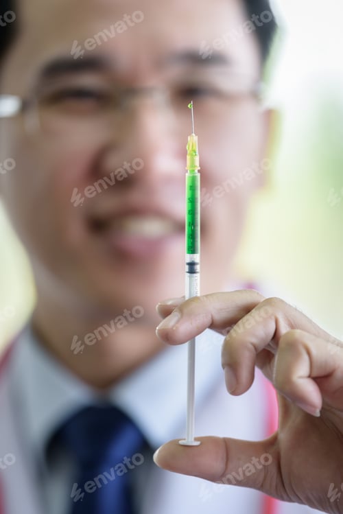 Preview: Professional Asian Doctor With Green Syringe And Splashing.