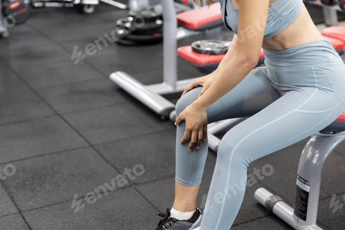 Preview: Asian Young Woman Having Knee Pain After Workout At The Gym. Painful During Exercise Training.