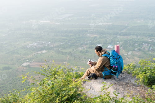 Preview: Man Journaling On Mountain Top With View