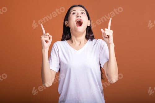 Preview: Excited Young Woman Pointing Upward with Joy