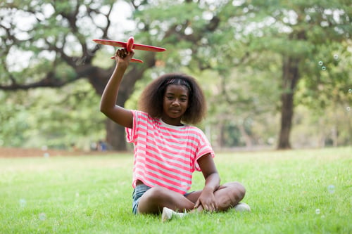 Preview: Happy Smiling African American Girl Playing With Toy Airplane Outdoor. Kid Having Fun With Toy