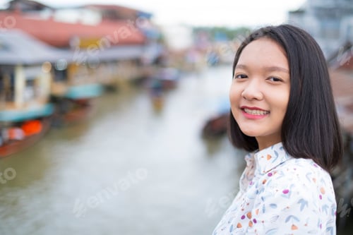 Preview: Asian Young Girl Smiling With View Of River And Old Town.