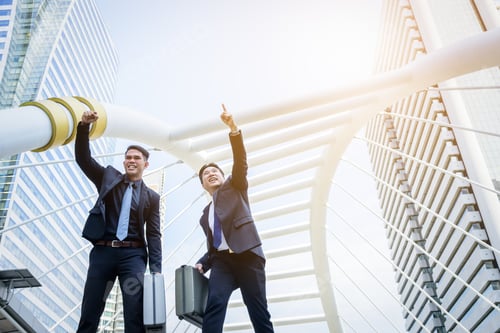 Preview: Two Asian Business Have Victory Of Business Goal With Building And City Background.