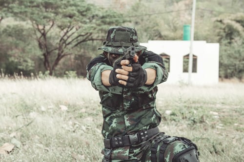 Preview: Soldier Aiming His Weapon. Kneeing Aiming His Pistol Down Range. Portrait Close Up Shot. Digital