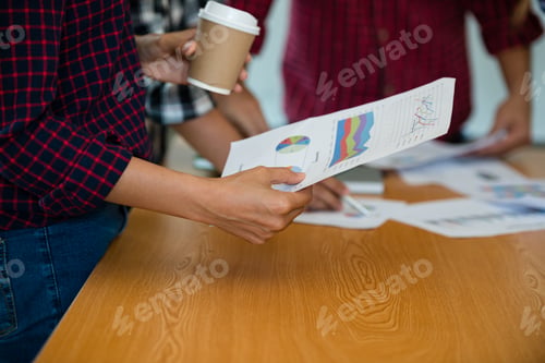 Preview: Hand Of Business Man Hold Graph Paper Charts, Market Reports During A Meeting In The Office
