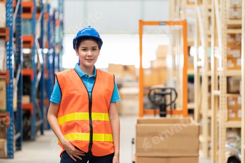 Preview: Asian Young Happy Female Warehouse Worker Wearing Safety Vest And Helmet At Work In The Industry