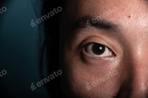 Preview: Extreme Close Up Of Young Chinese Male Eye With Dark Background. Asian Male. High Contrast Lighting.
