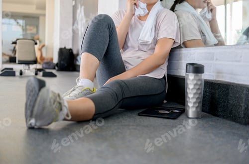 Preview: Asian Woman Workout And Working Online Alone At Gym. Social Distancing And New Normal Lifestyle.
