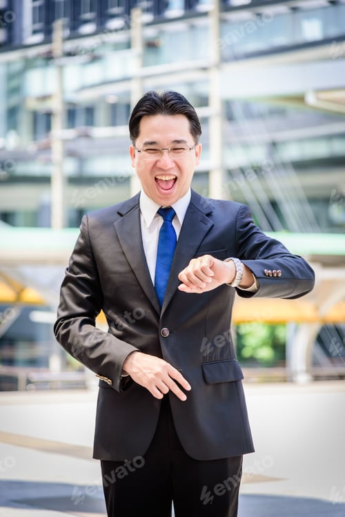 Preview: The Asian Businessman Has Holding A Black Bag And Looking On Watch In Hurrying Time.