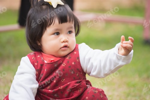Preview: Portrait Of Cute Baby Playing On The Lawn