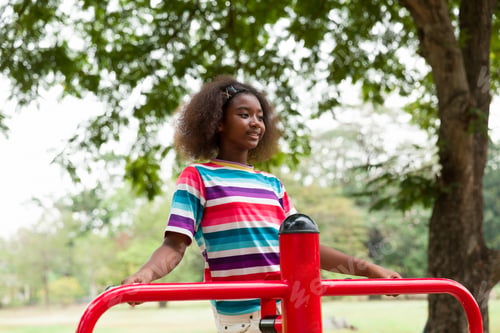 Preview: Cute African American Girl With Curly Hair Playing At The Playground In The Park.