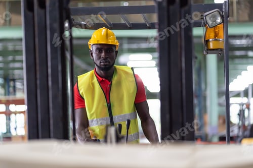 Preview: African American Male Warehouse Worker In Safety Vest And Helmet Driving And Operating On Forklift