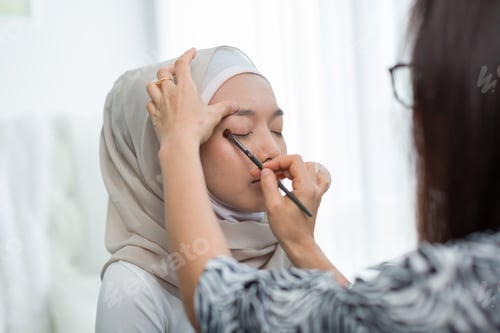 Preview: Makeup Artist Applying Powder With Brush Eyes Shadow With Young Muslim Woman In Hijab Head Scarf