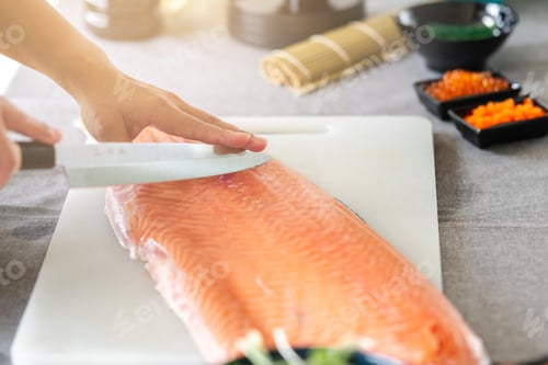 Preview: Chef Prepare To Cut Raw Salmon. Asian Woman Chef In Black Uniform, Large Sushi Knife On The Fish.