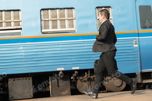 Preview: Young Asian Businessman Running To At Train Station In Hand Holding A Suitcase Laptop And Wearing