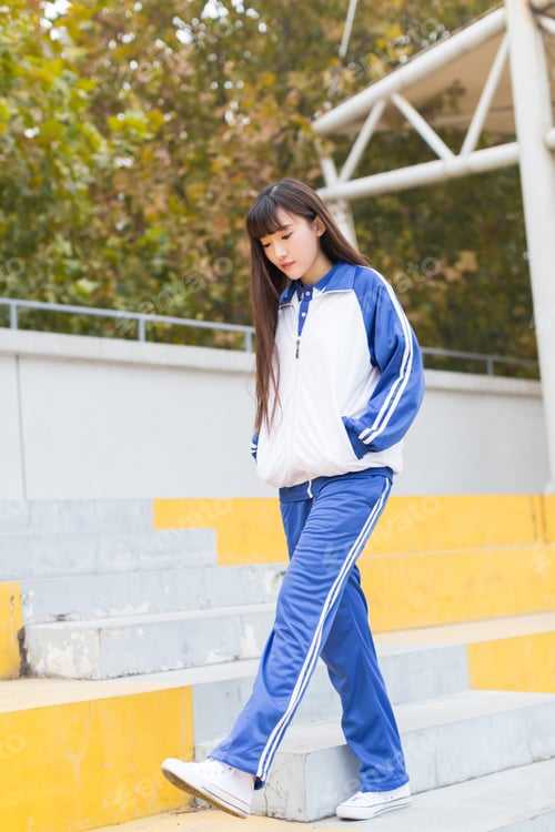 Vista previa: Pretty Girl With Long Hair Wearing Blue Uniforms, Stands On Campus