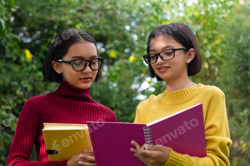 Preview: Two Happy Student Young Girl Wear Glasses Hold Note Book With Green Background.