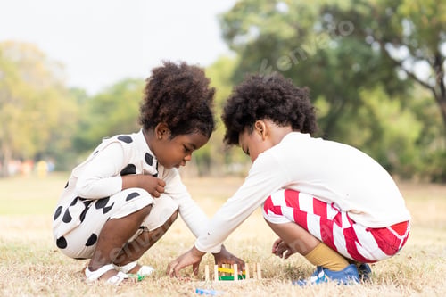 Preview: Two African American Little Boy And Girl Playing Toy Together In The Park. Children With Curly Hair