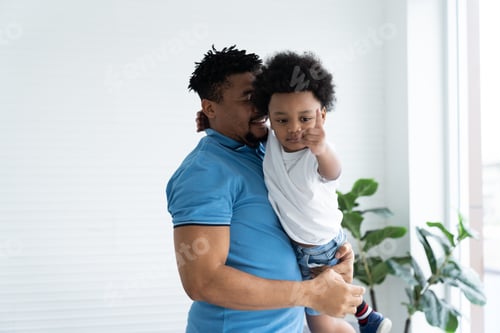 Preview: African American Dad Embracing Cute Curly Little Son In Room At Home. Happy African Family Spending