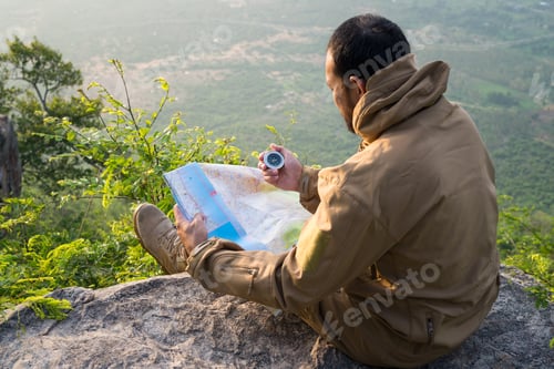 Preview: Traveler Young Man Searching Direction With A Compass And Map On Mountains. Adventures Hiking
