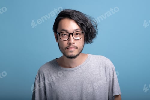 Preview: Young Bearded Man Portrait In Blue Background. Asian Young Hipster Smiling, Half Body Shot. Young