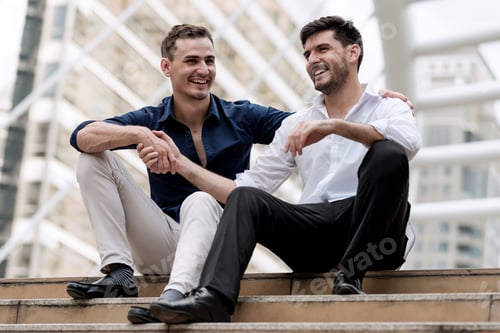Preview: Two Happy Businessmen Sitting Down On Concrete Stairs Shaking Hands. Sale Man And His Boss Shaking