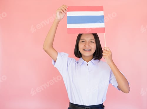 Preview: Portrait Asian Young Girl Hold Thai Flag With Pink Background In Student Uniform.