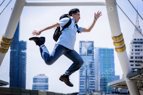 Preview: Asian Businessman Jumping With Building And Cityscape Background.