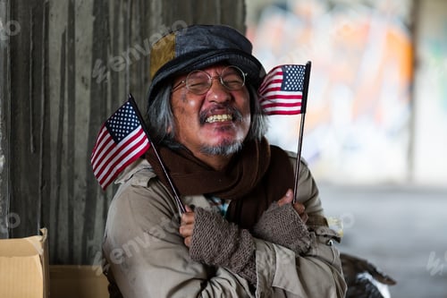 Preview: Homeless Elderly Man Wearing Hat Sitting, Smiling And Holding Flag Usa