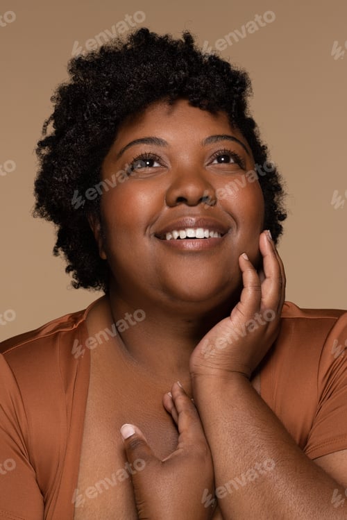 Preview: Studio Portrait Of Beautiful Overweight African American Woman In Her 20S Posing With Hand On Face