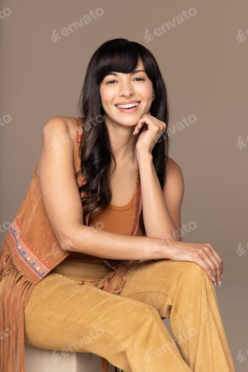 Preview: Studio Portrait Of Beautiful Native American Woman In Her 30S Sitting And Smiling On Neutral