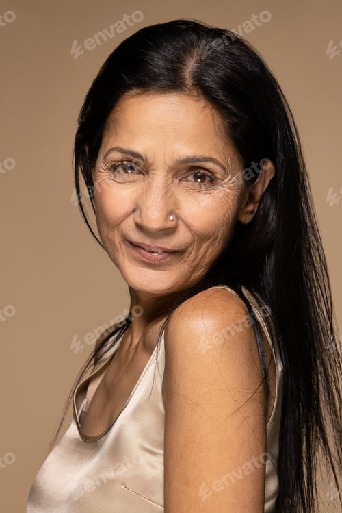 Preview: Portrait Of Beautiful East Indian Woman In Her 50S Smiling And Posing On Neutral Background