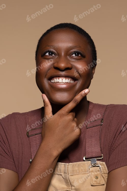 Preview: Portrait Of A Glowing Non-Binary Afro-Latino In Their 20'S Posing With Hand On Chin On A Neutral