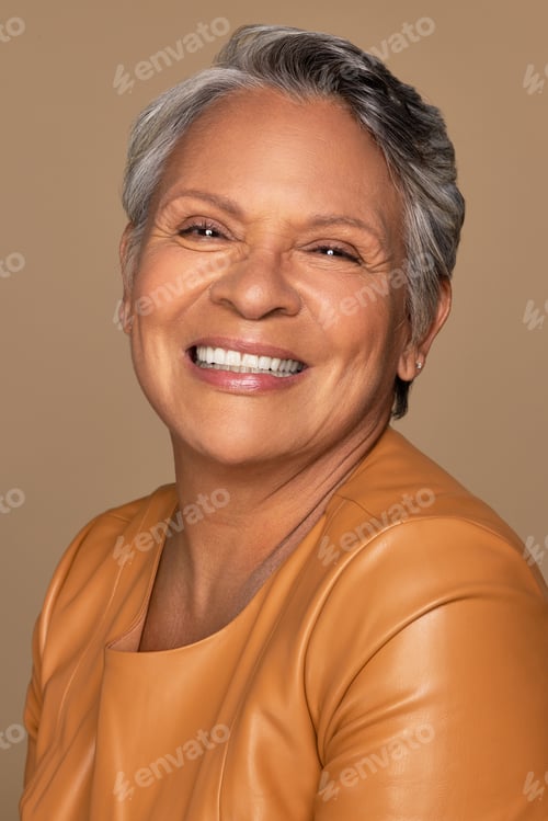Preview: Portrait Of Beautiful Hispanic Woman In Her 60S Smiling With Elegance And Posing On Neutral