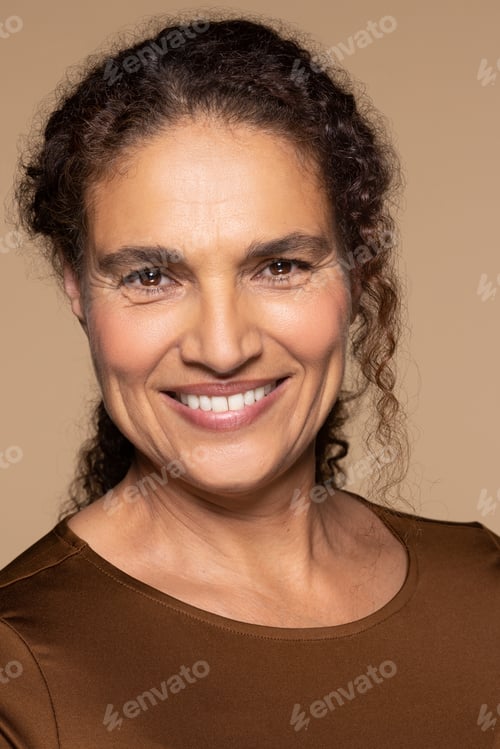 Preview: Portrait Of Beautiful Hispanic Woman In Her 50S Smiling Happy And Posing On Neutral Background