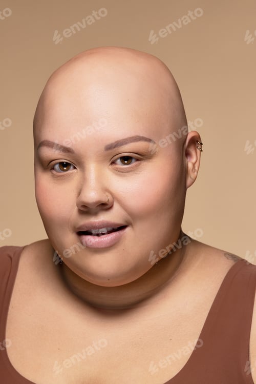 Preview: Portrait Of Beautiful Bald Woman In Her 20S With Alopecia Smiling On Neutral Background