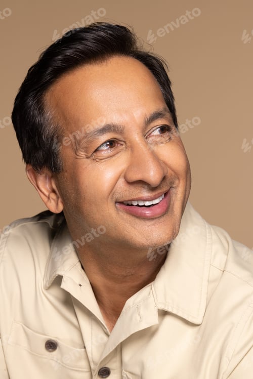 Preview: Studio Portrait Of Handsome Indian Man In His 50S Smiling On Neutral Background