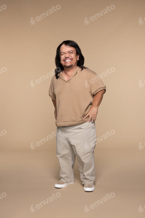 Preview: Studio Shot Of Hispanic Man In His 50S With Dwarfism Smiling And Posing On Neutral Background