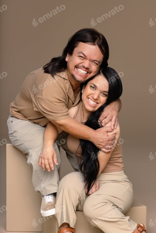 Preview: Studio Portrait Of A Hispanic Man In His 50S And A Hispanic Woman In Her 20S Posed Smiling On A