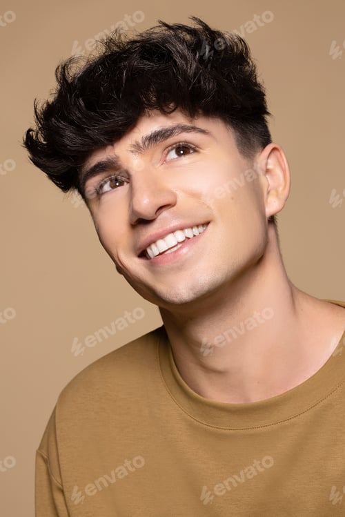 Preview: Close Up Portrait Of Young Non-Binary Caucasian Man In His 20S Smiling And Looking Up On Neutral
